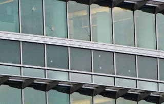 Windows on a CDC building pockmarked by bullet holes. The gunman struck at least four CDC buildings and killed a DeKalb County police officer, officials said